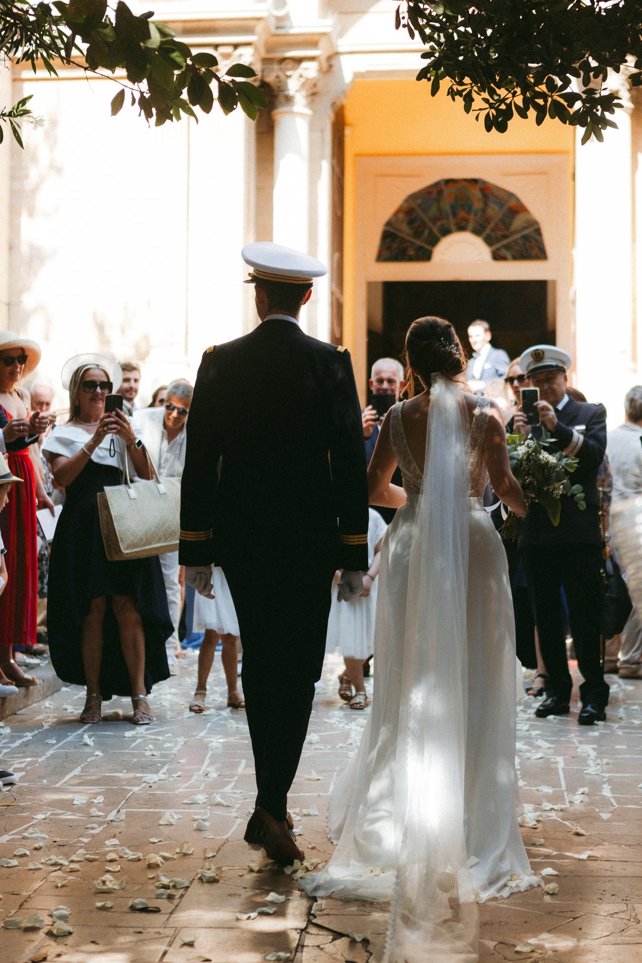Bride and groom walking through rose petals at a destination wedding ceremony